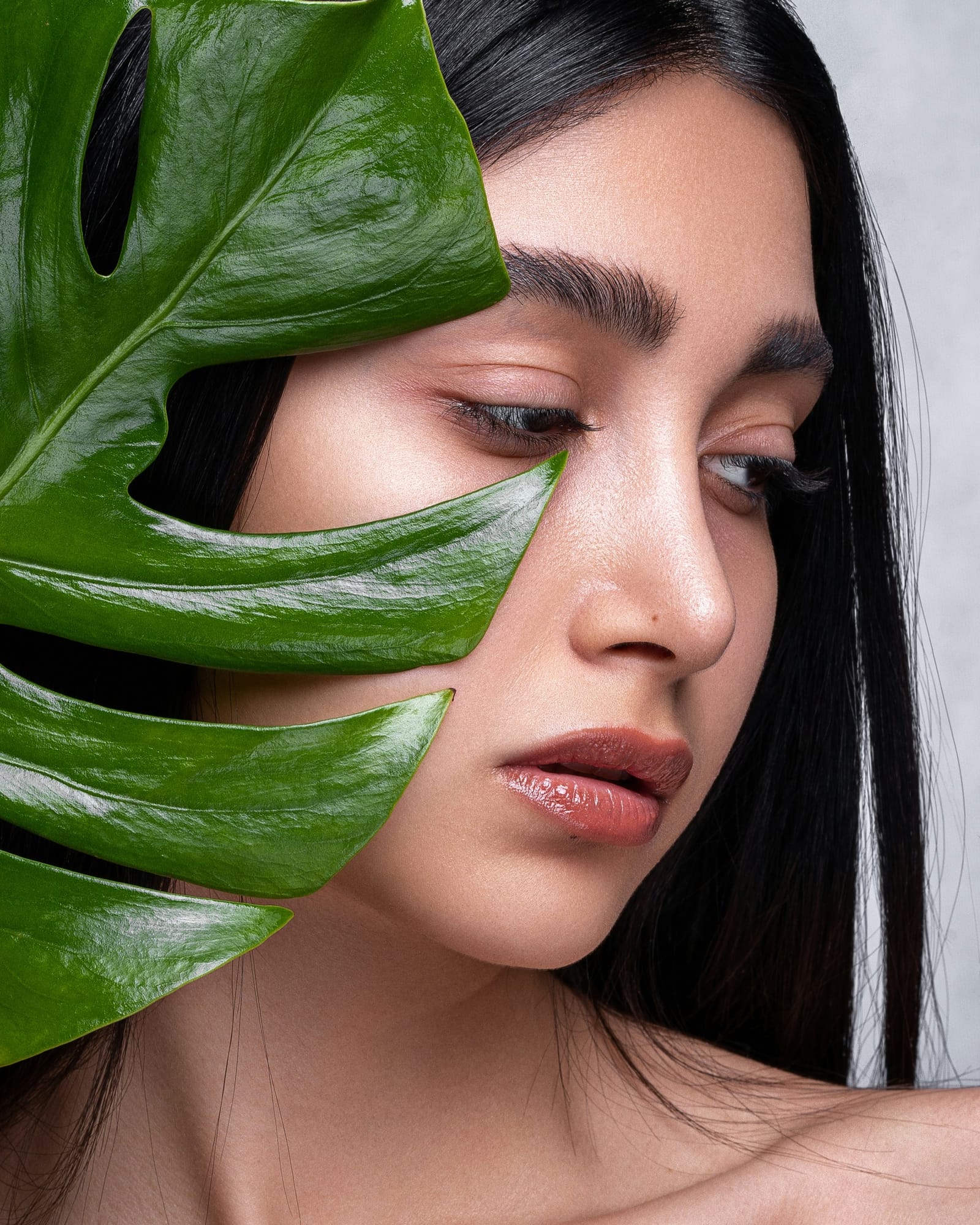 Portrait with monstera leaf, skin-first beauty